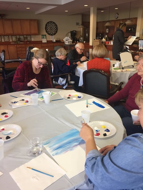 seniors painting at a table