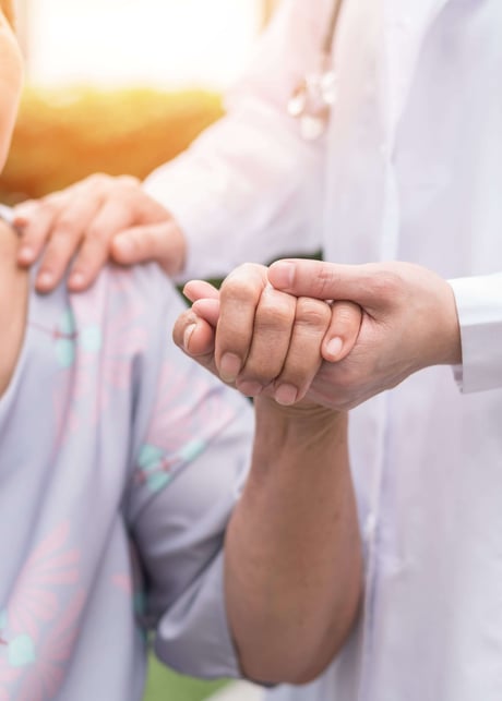 Elderly senior patient holding doctor's hand