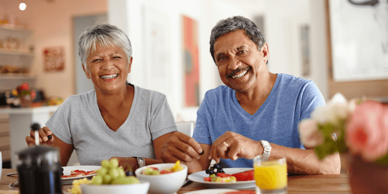 A happy senior couple enjoying a leisurely breakfast together at home