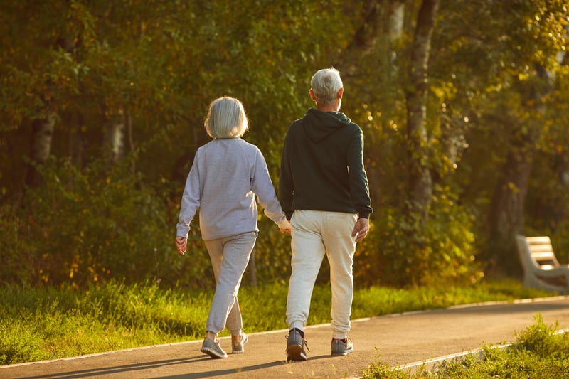 Married senior couple walking together on a sunny summer evening