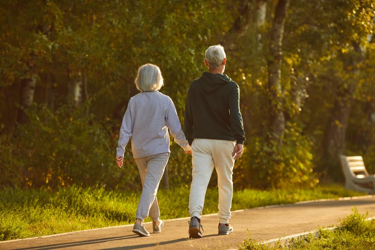 Married senior couple walking together on a sunny summer evening