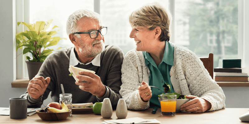 A retired senior couple enjoying a meal in their home