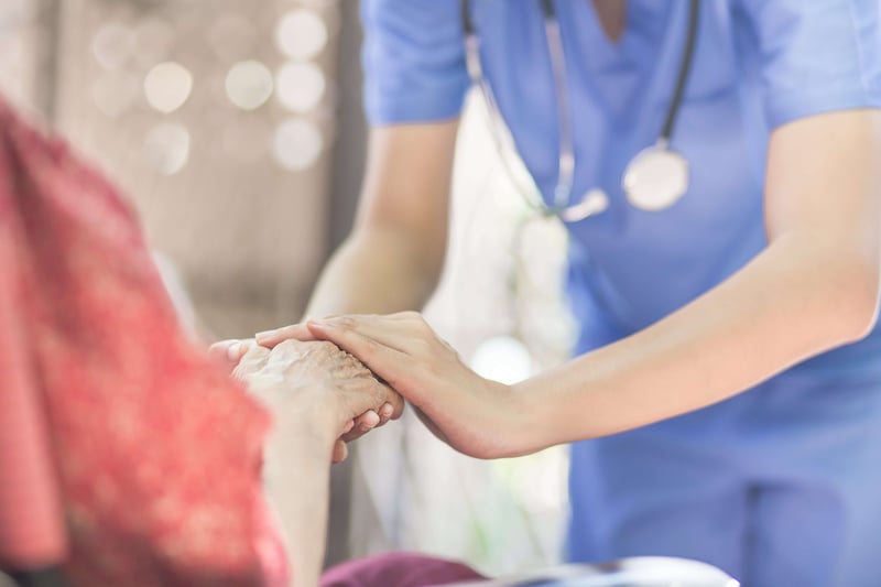 Hand of eldery woman with her caregiver at home