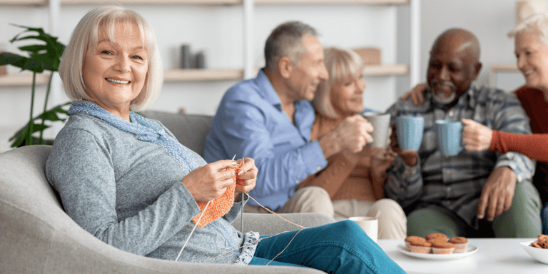 A woman knitting with friends in a senior living community