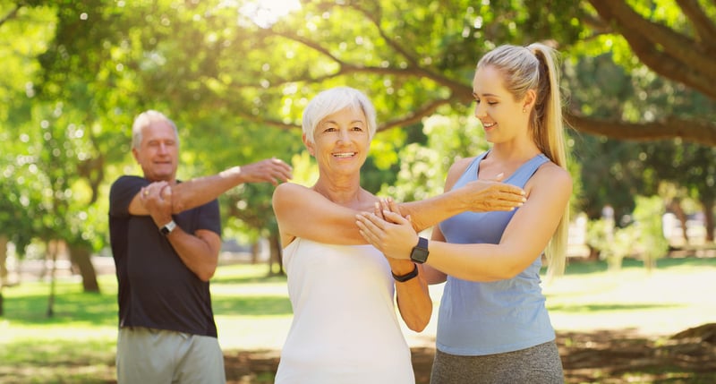 Senior couple with their personal trainer in a park for a healthy lifestyle