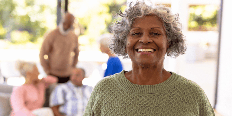 Portrait of smiling senior woman with her friends in the background