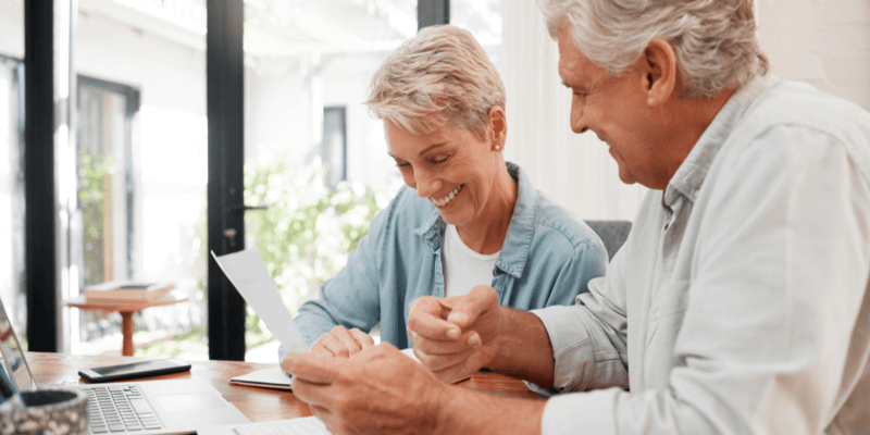 A senior couple reviewing documents together at the kitchen table