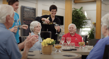 A group of seniors sitting around a table drinking wine