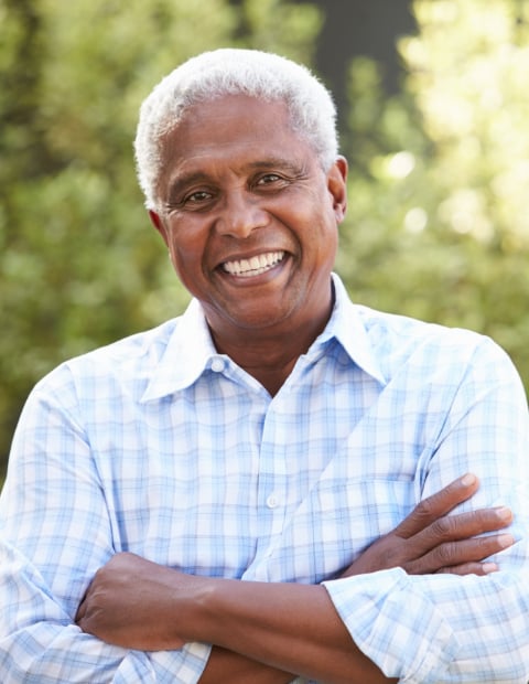 senior man smiling with crossed arms