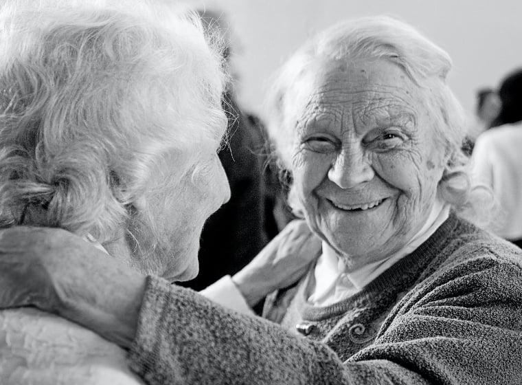 two senior women embracing and smiling