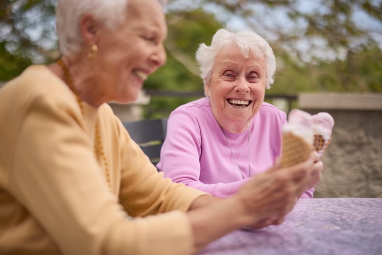 Two older woman ladies enjoying ice cream and having fun